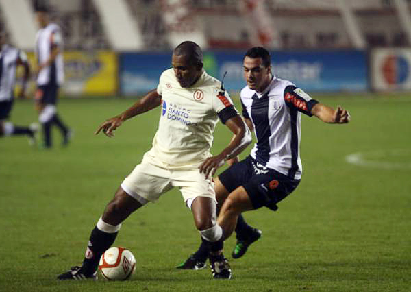 John Galliquio domina el esférico para evitar que Hernán Peirone se lo quite en el último clásico que se disputó un día viernes (Foto: larepublica.pe)