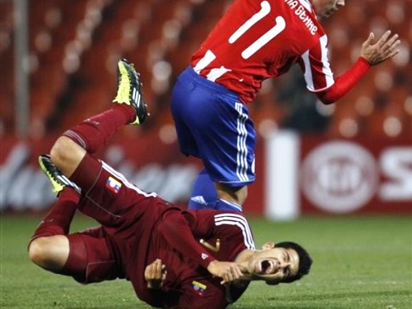CAYÓ FEO. Jonathan Santana hace una falta sobre Nicolás Fedor, que lleva al ariete venezolano a caer de mala forma. (Foto: AP)